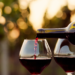 persona che riempie due bicchieri di vino rosso